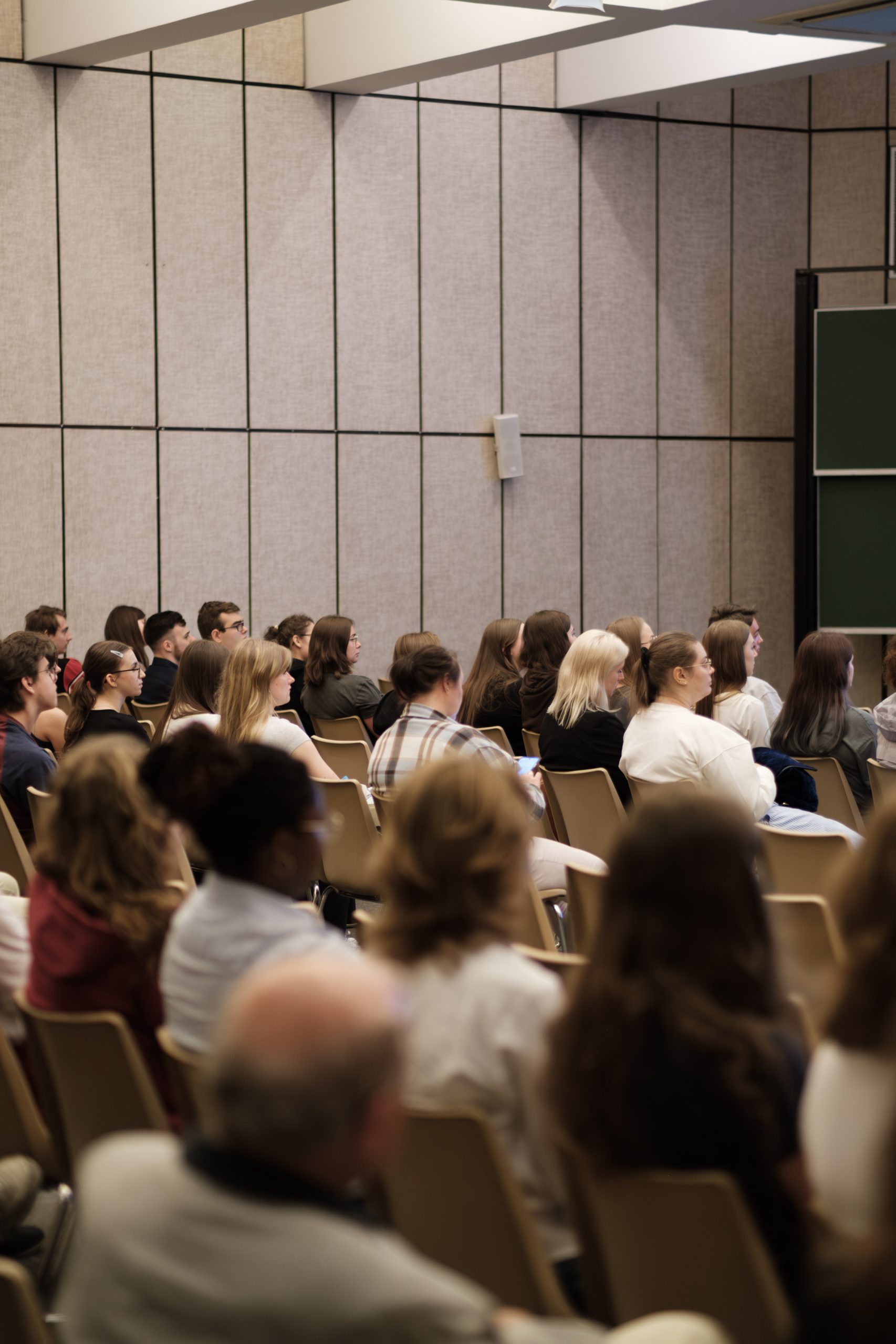 Duża grupa ludzi słuchających prezentacji w sali konferencyjnej