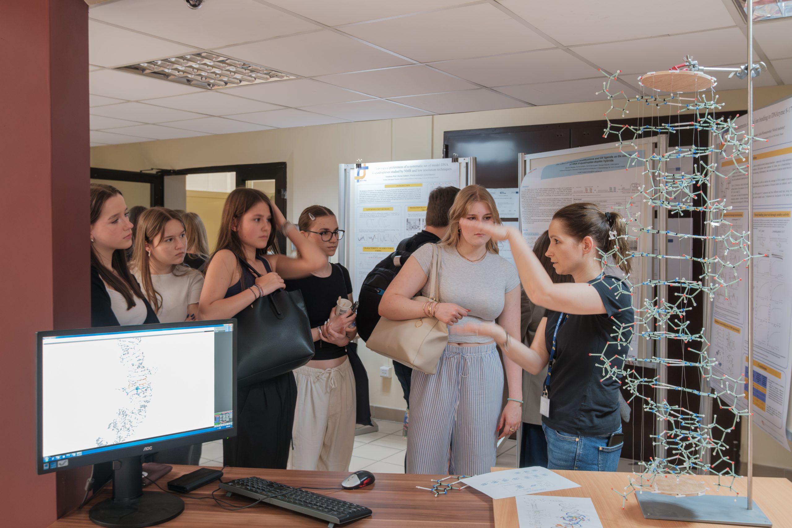 Kilka osób gromadzi się wokół komputera, omawiając dane na monitorze