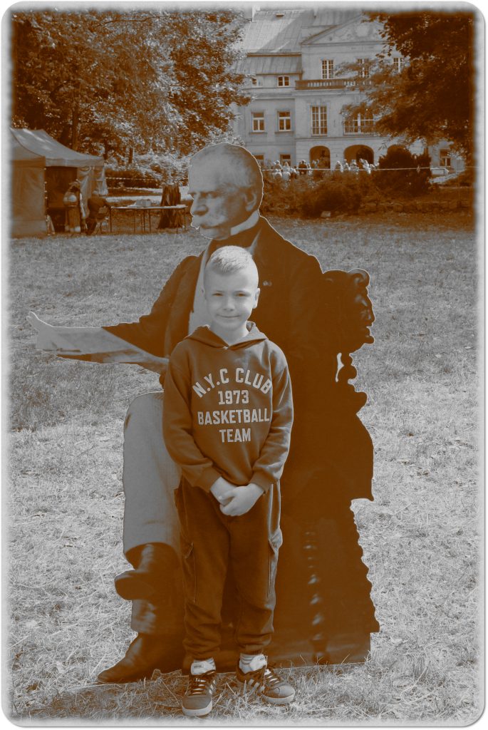 Sepia photo: a little boy in front of a large photo of General Dezydery Chłapowski; behind him, a meadow and a palace
