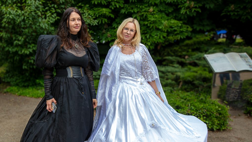 Two women in beautiful ball gowns, one in black, the other in white