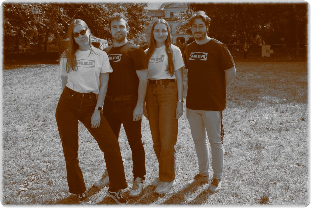 Sepia photo: a group of people, 2 women and 2 men; behind them, a meadow and a palace