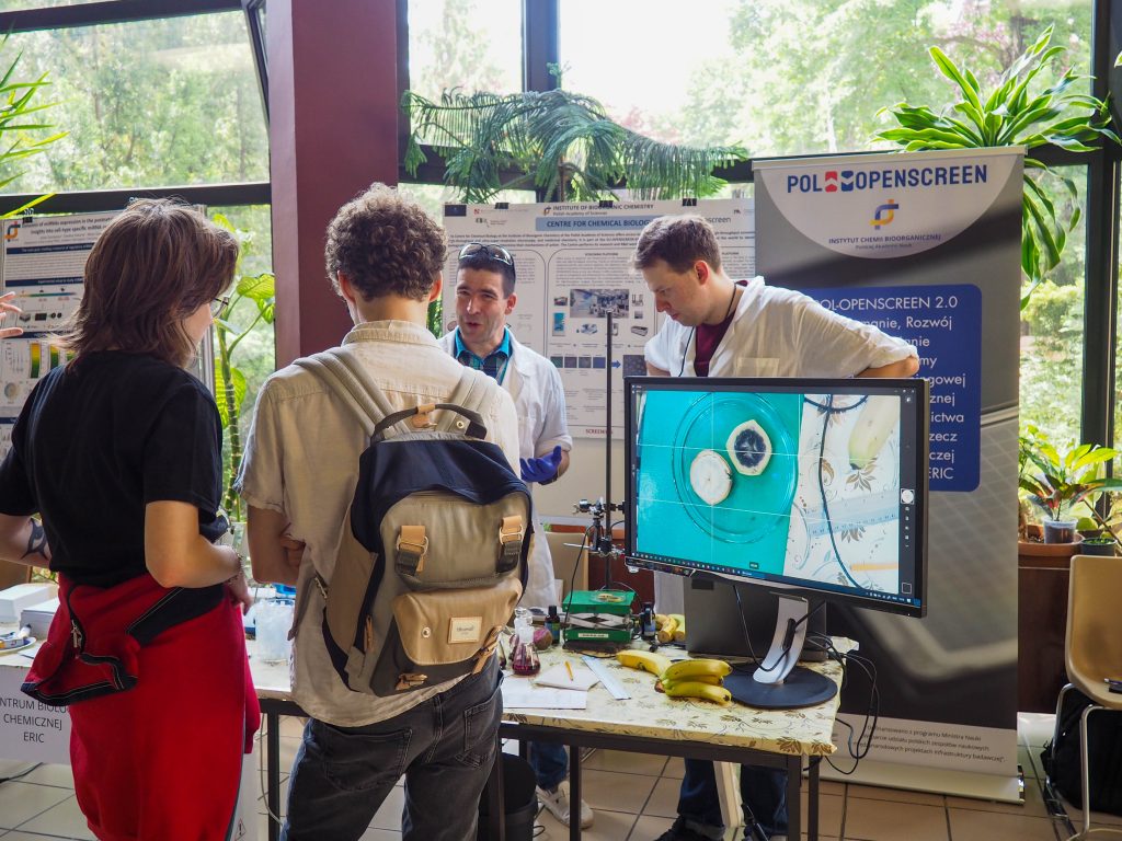 Dwóch naukowców opowiada i pokazuje na monitorze elementy pracy naukowca