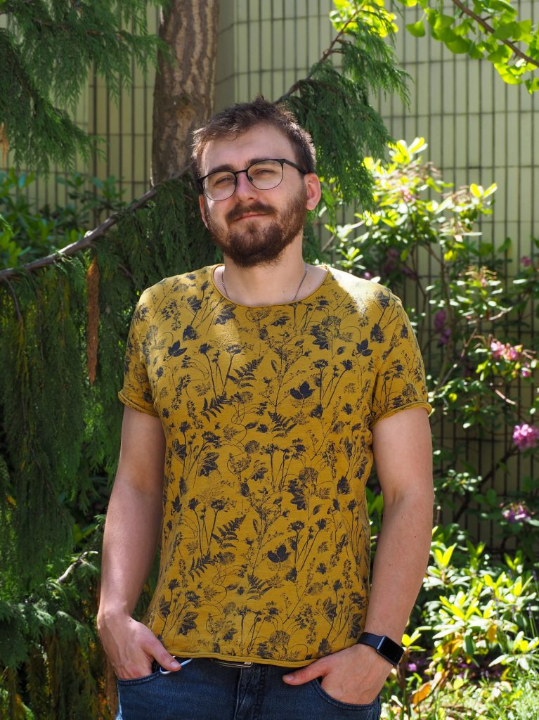 Portrait photograph of a smiling Martin Osuch, with plants in the background.