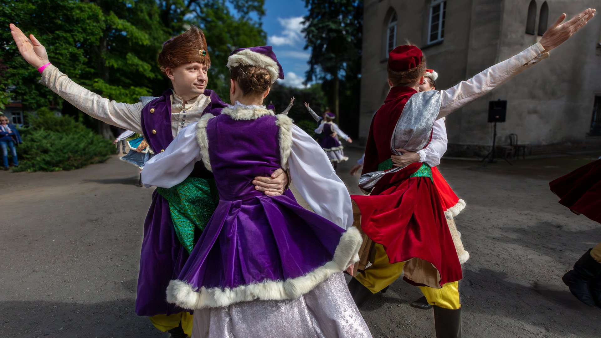 Zbliżenie na dwie pary taneczne zespołu tańca ludowego podczas występu przed Pałacem w Turwi