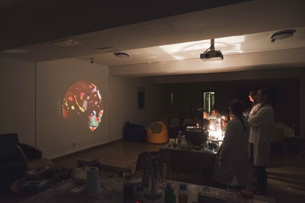 Scientists projecting an image from a microscope onto a wall.