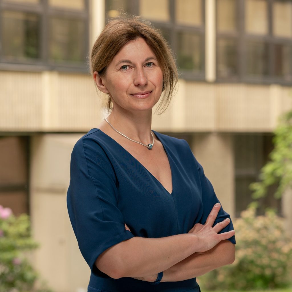 Portrait photo of Prof. Marta Szachniuk against the backdrop of IBCH PAS.