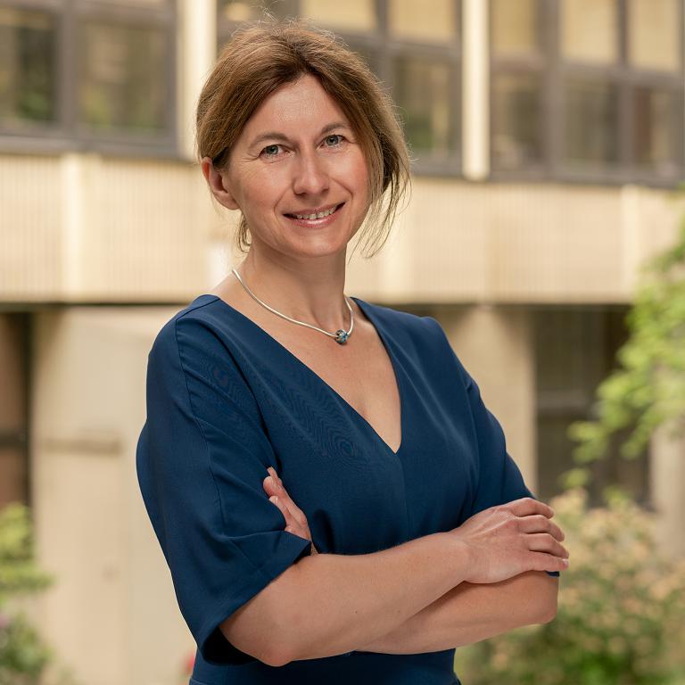 Portrait photograph of Prof. Marta Szachniuk smiling. A smiling woman against the backdrop of the Institute building