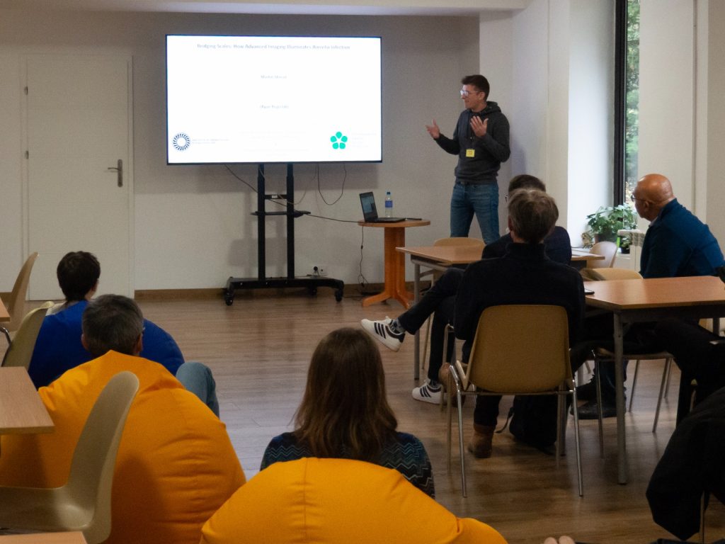 A scientist during a presentation. In front of him is a crowd of listeners