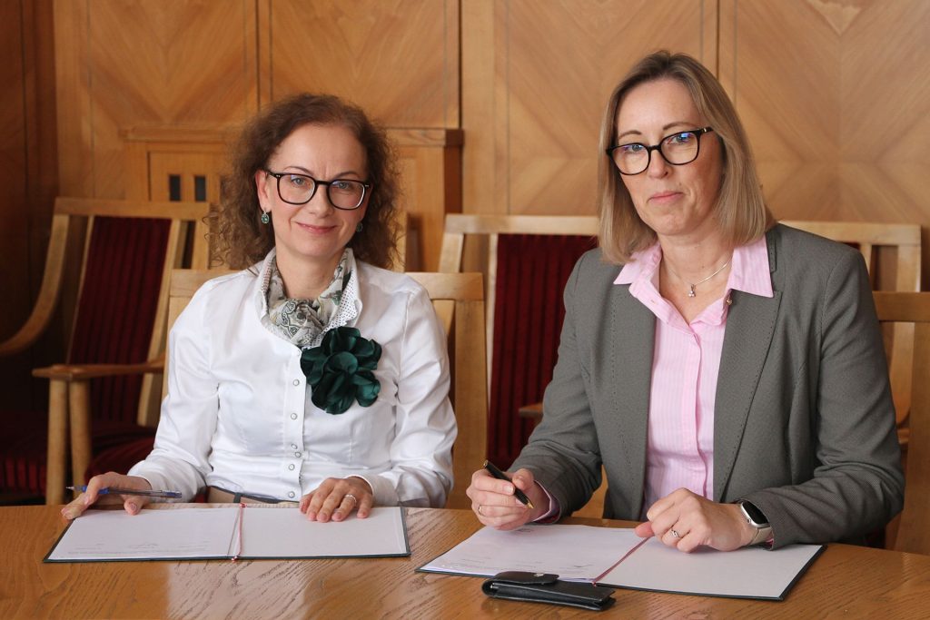 Director of IBCH PAS, Prof. Luiza Handschuh and Rector of Poznań University of Economics and Business, Prof. Barbara Jankowska, signing the agreement at the table.