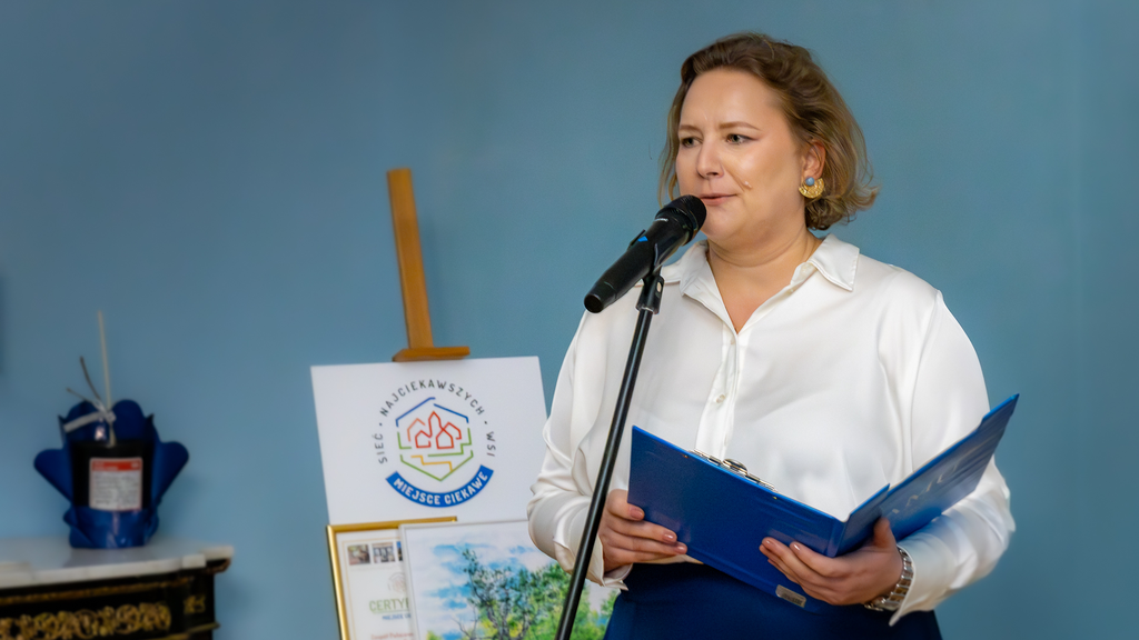 Kobieta z mikrofonem prowadząca uroczystość.