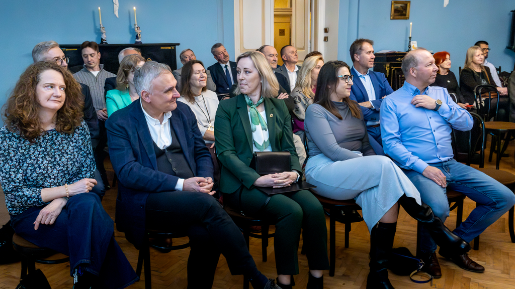 Osoby różnej płci siedzące w salonie Pałacu w Turwi – goście uroczystości.