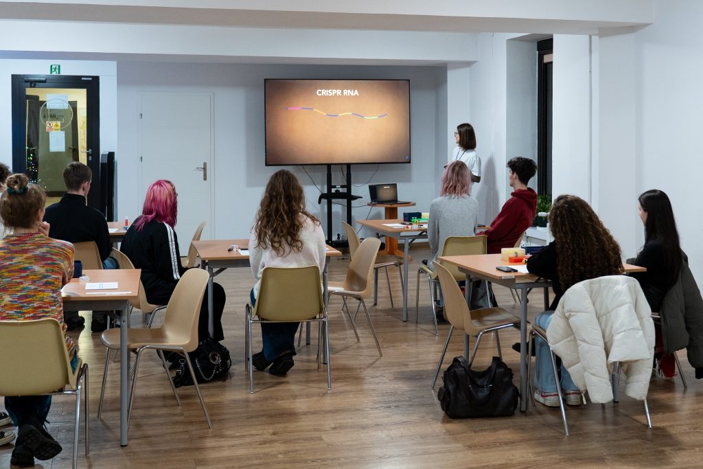 Young people listening to a lecture about CRISPR molecular scissors.