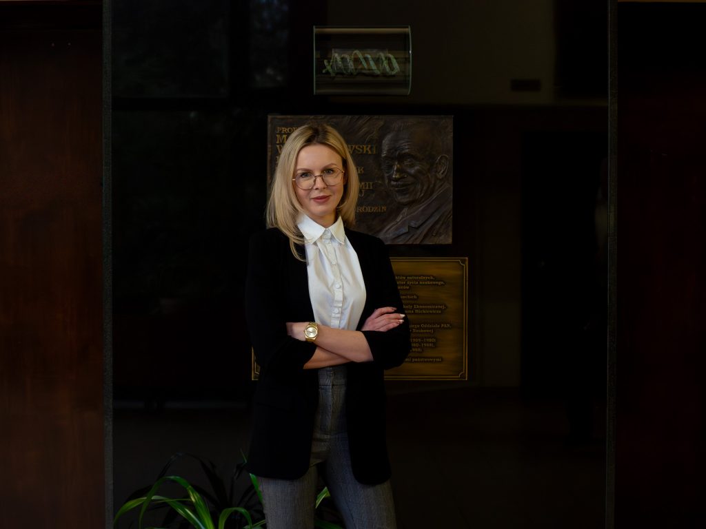 A portrait photograph of Natalia Szóstak next to the commemorative plaque of the Institute’s founder