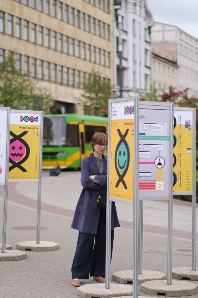 Waiting for the exhibition to open. A woman looking at one of the posters
